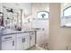 The main bathroom has an abundance of mirrors, neutral tile and dark hardware at 4386 Library St, Port Charlotte, FL 33948