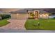 Stunning single-story home with manicured lawn, brick driveway, and three-car garage at 4386 Library St, Port Charlotte, FL 33948