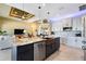 Open kitchen featuring a large island, copper farmhouse sink, stainless steel appliances, and custom lighting at 4386 Library St, Port Charlotte, FL 33948