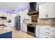 The gourmet kitchen features stainless steel appliances, custom cabinetry, and a decorative range hood at 4386 Library St, Port Charlotte, FL 33948