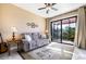Cozy living room with plush sofa, ceiling fan, and access to the screened patio at 4386 Library St, Port Charlotte, FL 33948