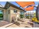 Relaxing screened-in patio with lounge chairs and stylish sunshade, perfect for outdoor entertaining at 4386 Library St, Port Charlotte, FL 33948