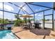 An outdoor dining area, barbeque, and waterfront view complement the screened-in pool and brick patio in this sunny outdoor space at 4386 Library St, Port Charlotte, FL 33948