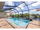Beautiful outdoor space featuring a lovely in-ground pool, brick patio, and scenic waterfront view at 4386 Library St, Port Charlotte, FL 33948
