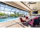 Screened lanai with a beautiful pool, comfortable seating, ceiling fans and a picturesque waterfront view creates an inviting outdoor living area at 4386 Library St, Port Charlotte, FL 33948