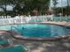 Outdoor pool with a ramp entry, surrounded by lounge chairs and lush greenery at 4425 45Th W Ave # 101, Bradenton, FL 34210