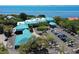 Stunning aerial view of a building featuring a distinctive turquoise roof, surrounded by lush trees and a parking lot at 4535 Bay Club Dr, Bradenton, FL 34210