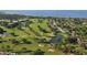 Expansive aerial view of a meticulously designed golf course with lush greenery, serene ponds, and luxury homes at 4535 Bay Club Dr, Bradenton, FL 34210