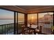 Balcony with large windows showcases sunset and ocean views in the distance at 4535 Bay Club Dr, Bradenton, FL 34210