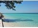 Scenic beach view with clear turquoise water, white sand, and a staircase leading to the shore at 4535 Bay Club Dr, Bradenton, FL 34210