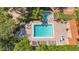 Aerial view of a community pool and spa surrounded by lush landscaping and lounging areas at 4535 Bay Club Dr, Bradenton, FL 34210