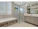 Elegant bathroom featuring a soaking tub, shower, dual vanity, and storage shelves at 5103 Windward Ave, Sarasota, FL 34242