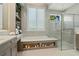 Elegant bathroom featuring a soaking tub, shower, dual vanity, and storage shelves at 5103 Windward Ave, Sarasota, FL 34242