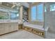 Elegant bathroom featuring a soaking tub, shower, dual vanity, and storage shelves at 5103 Windward Ave, Sarasota, FL 34242