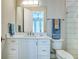 Bright bathroom with dual towel bars, updated vanity and fixtures, and glass-enclosed shower at 5103 Windward Ave, Sarasota, FL 34242