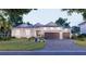 Beautiful single-story home featuring a three-car garage, manicured lawn, and a paver driveway at 5103 Windward Ave, Sarasota, FL 34242