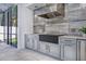 Outdoor kitchen with stainless hood vent, integrated sink, stone backsplash, and ample counter space at 5103 Windward Ave, Sarasota, FL 34242