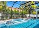 This screened-in pool features a spa, water feature, and ample space for lounging in a backyard oasis at 5103 Windward Ave, Sarasota, FL 34242
