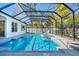 Beautiful screened-in pool with a spa, surrounded by lush landscaping for ultimate privacy at 5103 Windward Ave, Sarasota, FL 34242