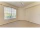 Bedroom features neutral carpet, neutral paint, ceiling fan and view to nature at 5160 Northridge Rd # 302, Sarasota, FL 34238