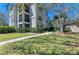 Exterior view of a condo with a well-maintained lawn and garden, enhanced by mature trees and a sidewalk at 5160 Northridge Rd # 302, Sarasota, FL 34238