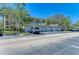 Image showing garage parking for the condo building, with a green tile roof and lush landscaping around the parking area at 5160 Northridge Rd # 302, Sarasota, FL 34238
