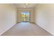 Open living room with neutral carpet, ceiling fan, and balcony access at 5160 Northridge Rd # 302, Sarasota, FL 34238