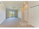 Open living room with neutral carpet, ceiling fan, and entry door at 5160 Northridge Rd # 302, Sarasota, FL 34238