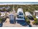 Aerial view of beachfront home with three car garage and manicured lawn surrounded by neighboring homes at 534 Beach Rd, Sarasota, FL 34242