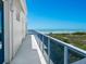Breathtaking balcony view showcasing modern railing and panoramic ocean vistas with pristine beachfront and lush vegetation at 534 Beach Rd, Sarasota, FL 34242