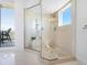 This renovated bathroom features a large glass shower, neutral finishes and an exterior balcony at 534 Beach Rd, Sarasota, FL 34242