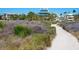 Inviting sandy beach path surrounded by lush greenery leading towards the desirable property at 534 Beach Rd, Sarasota, FL 34242