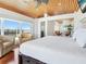 Bright bedroom boasts vaulted wood ceiling and large picture windows with ocean views at 534 Beach Rd, Sarasota, FL 34242