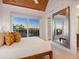 Bedroom with wood ceiling and floor, large window with water view and a decorative mirror at 534 Beach Rd, Sarasota, FL 34242