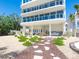 Elegant home exterior with covered patio, lush landscaping, outdoor kitchen, and stepping stone pathway at 534 Beach Rd, Sarasota, FL 34242