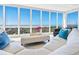 Bright living room features a modern white leather sofa with floor to ceiling windows offering beach views at 534 Beach Rd, Sarasota, FL 34242