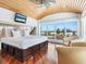 Bright main bedroom boasting wood flooring, a ceiling fan, TV, and panoramic water views through expansive windows at 534 Beach Rd, Sarasota, FL 34242