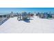 Spacious rooftop terrace furnished with blue chairs and tables, offering stunning ocean views for relaxing or entertaining guests at 534 Beach Rd, Sarasota, FL 34242