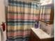 This bathroom features vanity with a mirror and a shower with a bright, patterned curtain at 540 Palmetto Ne Dr, Port Charlotte, FL 33952