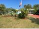 Charming single-story home with lush landscaping, tropical plants, and a vibrant green lawn at 540 Palmetto Ne Dr, Port Charlotte, FL 33952