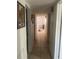 A narrow hallway with neutral tile flooring connecting different areas of the home at 540 Palmetto Ne Dr, Port Charlotte, FL 33952