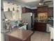 Kitchen with dark wood cabinets, stainless steel refrigerator, and a view into the living area at 540 Palmetto Ne Dr, Port Charlotte, FL 33952
