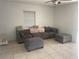 Comfortable living room featuring tile floors, a window, and a large sectional sofa at 540 Palmetto Ne Dr, Port Charlotte, FL 33952
