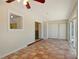 Cozy living room with terracotta tile flooring, ceiling fan, and a sliding glass door to enjoy the outdoors at 5422 Nutmeg Ave, Sarasota, FL 34231