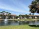 A condo community on a lake with a water fountain, lush trees, and a beautiful, sunny blue sky at 5734 Ashton Lake Dr # 7, Sarasota, FL 34231
