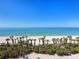 Scenic beach view with white sand, clear water, and lush palm trees at 575 Sanctuary Dr # A304, Longboat Key, FL 34228