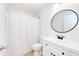 Updated bathroom features new vanity, round mirror, toilet and shower with curtain at 612 Ironwood Cir # 170, Venice, FL 34292