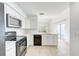 Clean kitchen featuring white cabinets, stainless appliances, tile backsplash, and ample counter space at 612 Ironwood Cir # 170, Venice, FL 34292