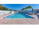 Clean community pool with blue tile edging with lounge chairs and tables for relaxing at 612 Ironwood Cir # 170, Venice, FL 34292