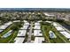 An aerial view showcases a neighborhood featuring well-maintained homes, lush greenery, and tranquil waterway views at 6902 8Th W Ave, Bradenton, FL 34209